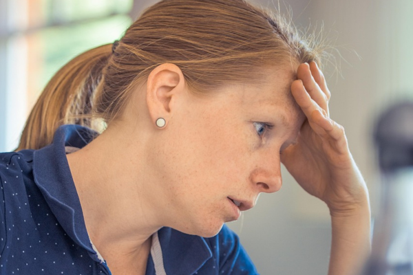 vrouw met hand aan hoofd en stress